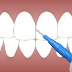 Persona cepillando los dientes con un cepillo de cerdas suaves, clave para prevenir la caries dental